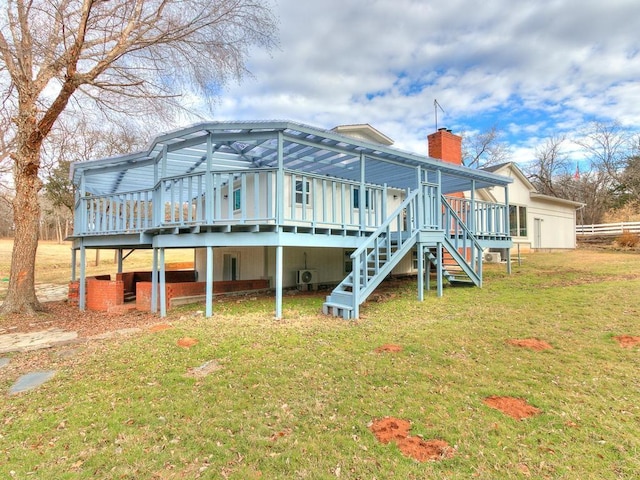 rear view of property with a lawn and a deck