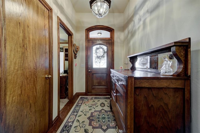 doorway featuring baseboards and an inviting chandelier