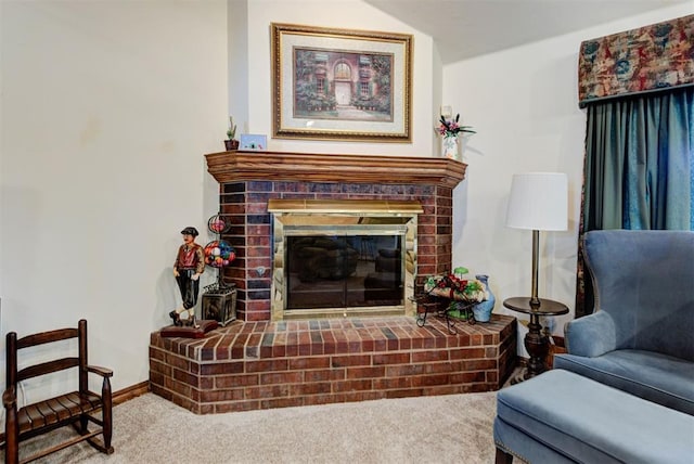 sitting room with carpet floors, a brick fireplace, and baseboards