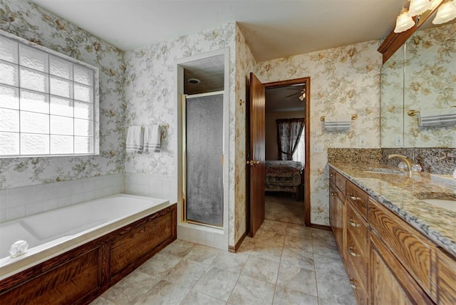 ensuite bathroom featuring connected bathroom, a sink, a shower stall, double vanity, and wallpapered walls