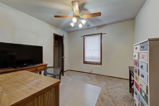 carpeted office featuring a ceiling fan and baseboards