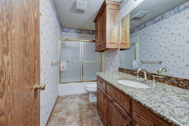 bathroom with wallpapered walls, visible vents, toilet, combined bath / shower with glass door, and vanity