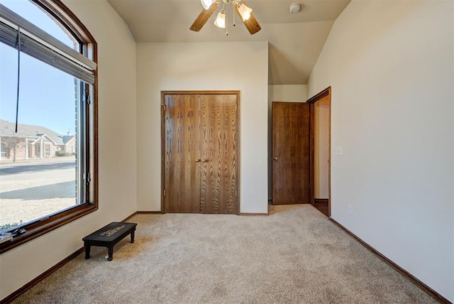 unfurnished bedroom with a closet, carpet flooring, vaulted ceiling, ceiling fan, and baseboards