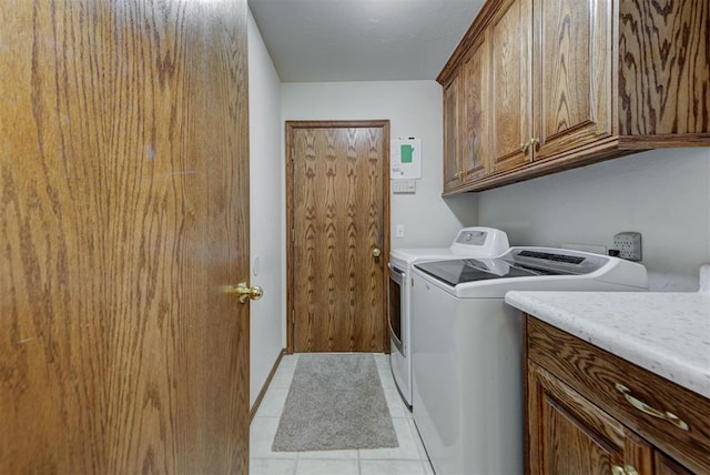 washroom with cabinet space, washing machine and dryer, and light tile patterned floors