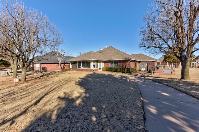 rear view of house with a sunroom and brick siding