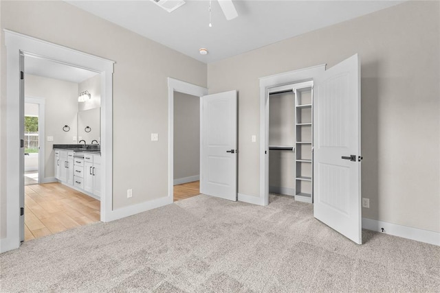 unfurnished bedroom featuring connected bathroom, light carpet, ceiling fan, and a closet