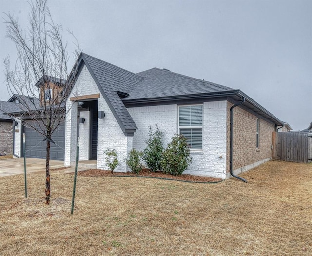 view of front of house featuring a garage and a front lawn