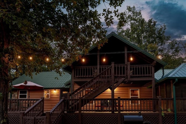 back house at dusk featuring a deck