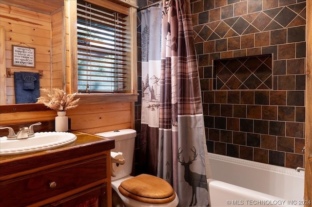 full bathroom with vanity, shower / bath combo, toilet, and wood walls