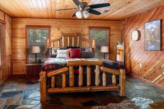 bedroom featuring multiple windows, wooden walls, and wood ceiling