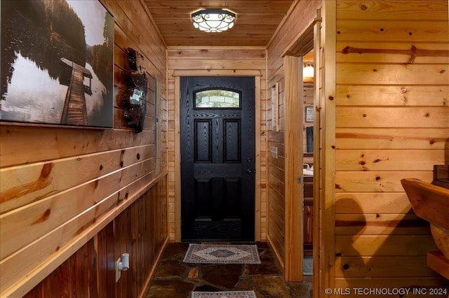 doorway to outside with wood ceiling and wood walls