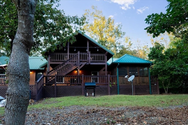 back of house with a sunroom and a deck