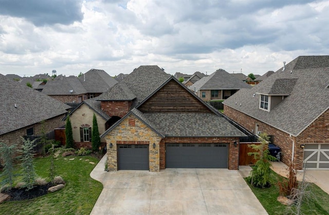 view of front facade featuring driveway, a shingled roof, an attached garage, and a residential view