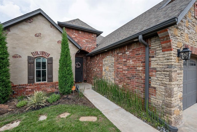 view of exterior entry with a shingled roof, stone siding, brick siding, and an attached garage