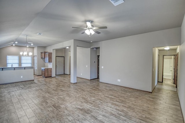 unfurnished living room featuring lofted ceiling, sink, ceiling fan with notable chandelier, and light wood-type flooring