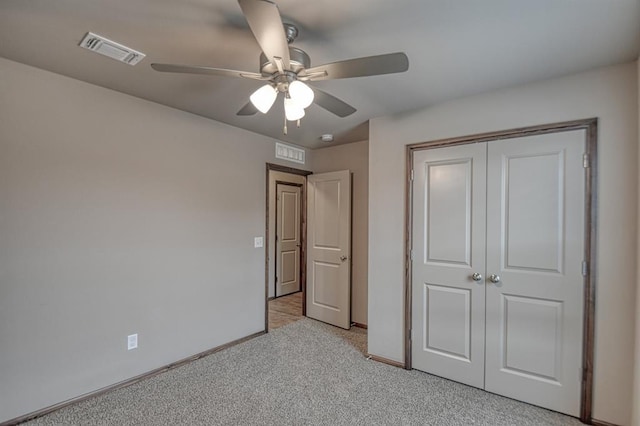 unfurnished bedroom with light colored carpet, a closet, and ceiling fan