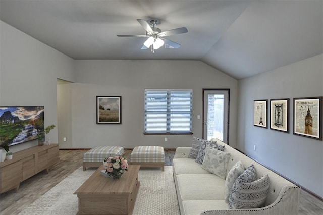 living room featuring ceiling fan, lofted ceiling, and light wood-type flooring