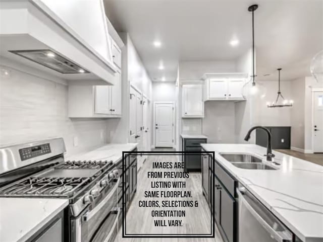 kitchen featuring sink, custom exhaust hood, light stone counters, stainless steel appliances, and white cabinets