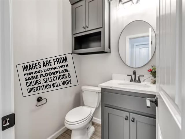 bathroom featuring vanity, hardwood / wood-style floors, and toilet