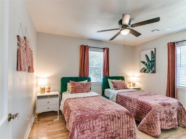 bedroom featuring multiple windows, light hardwood / wood-style floors, and ceiling fan