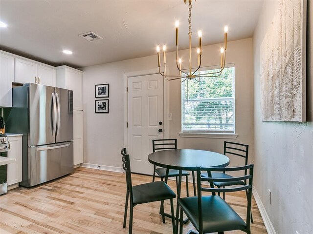 dining area with an inviting chandelier and light wood-type flooring