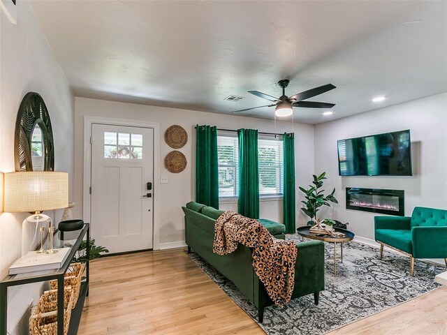 living room featuring ceiling fan, a healthy amount of sunlight, and light hardwood / wood-style flooring