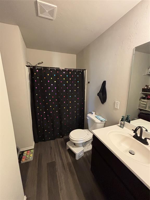 bathroom featuring vanity, a shower with curtain, wood-type flooring, and toilet