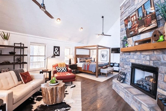 bedroom with a fireplace, high vaulted ceiling, and wood-type flooring