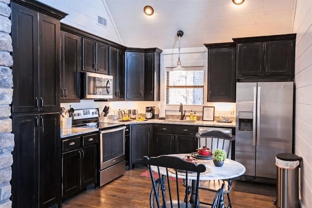 kitchen featuring lofted ceiling, sink, pendant lighting, stainless steel appliances, and dark hardwood / wood-style flooring