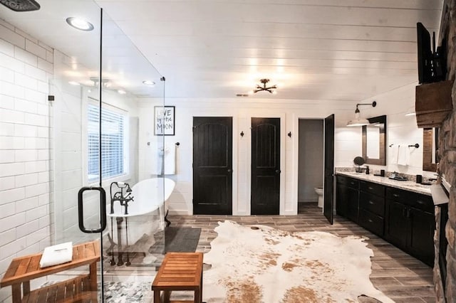 bathroom with vanity, a bathtub, and toilet