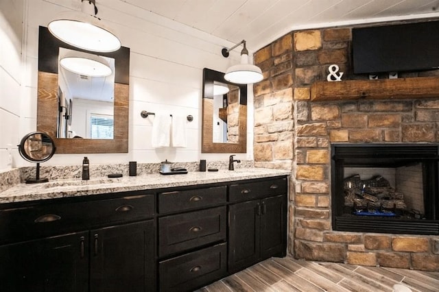 bathroom featuring vanity and a stone fireplace