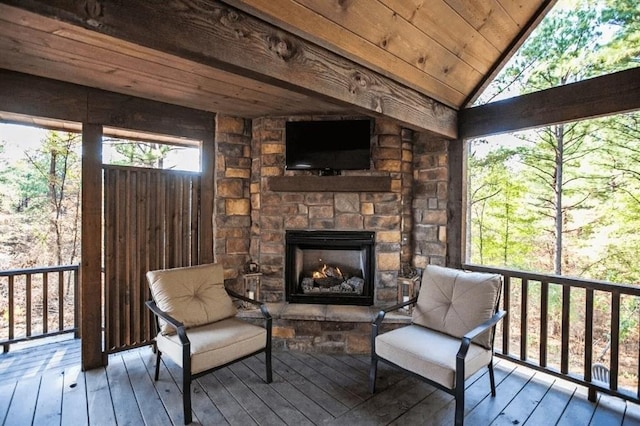 sunroom / solarium featuring lofted ceiling, wooden ceiling, and an outdoor stone fireplace