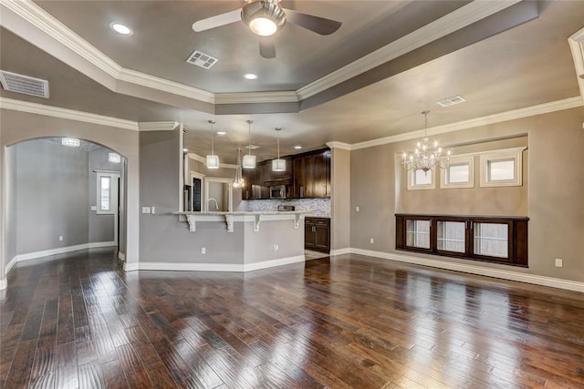 unfurnished living room featuring a raised ceiling, visible vents, and dark wood finished floors