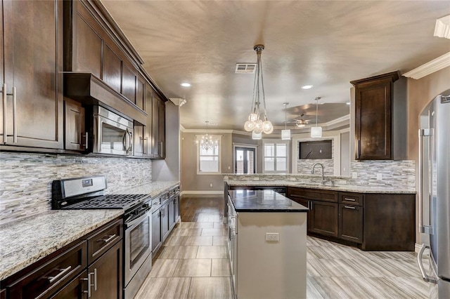 kitchen with a sink, visible vents, appliances with stainless steel finishes, dark stone counters, and pendant lighting