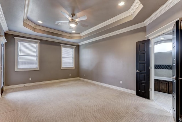 spare room featuring baseboards, a raised ceiling, a ceiling fan, and light colored carpet