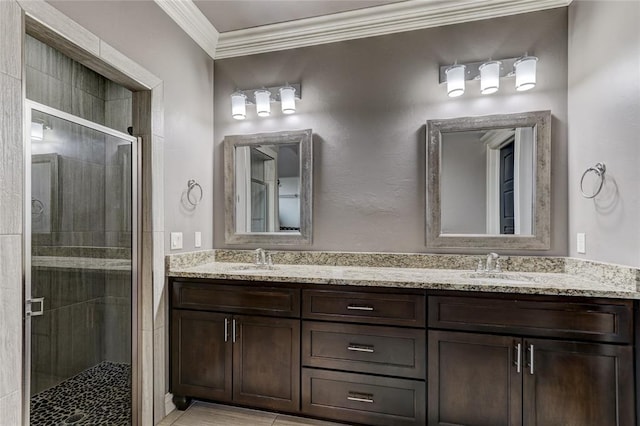 bathroom featuring a sink, double vanity, a shower stall, and crown molding