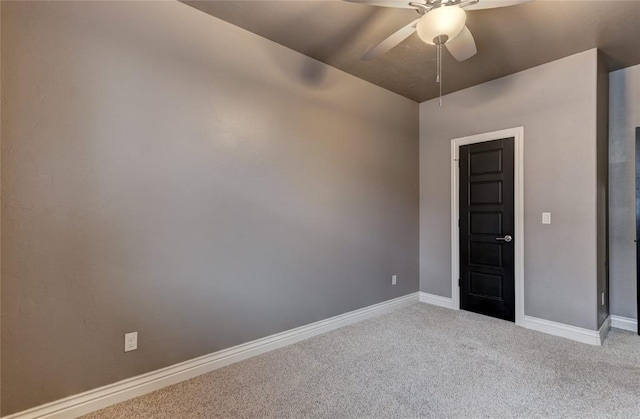 spare room with baseboards, a ceiling fan, and light colored carpet