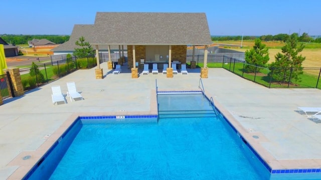 community pool with fence and a patio