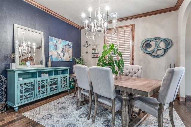 dining space featuring ornamental molding, dark wood-type flooring, and an inviting chandelier