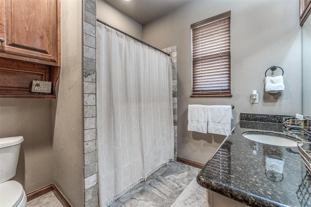 bathroom featuring vanity, curtained shower, and toilet