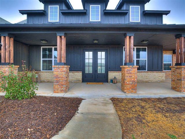 entrance to property featuring a porch and french doors