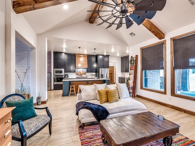 living room with vaulted ceiling with beams, ceiling fan, and light wood-type flooring