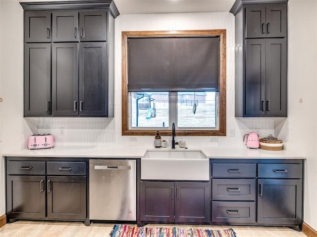 kitchen with tasteful backsplash, sink, stainless steel dishwasher, and light hardwood / wood-style floors