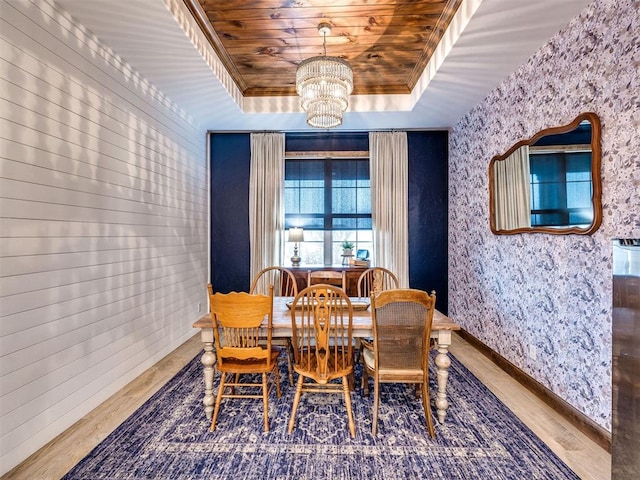 dining room with crown molding, hardwood / wood-style flooring, a notable chandelier, a tray ceiling, and wooden ceiling