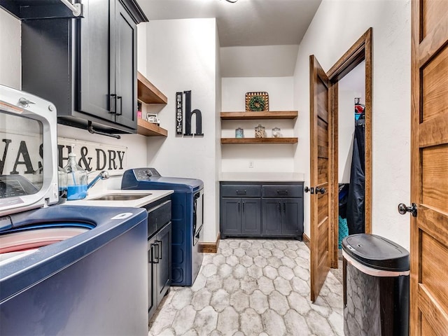 clothes washing area featuring separate washer and dryer and cabinets