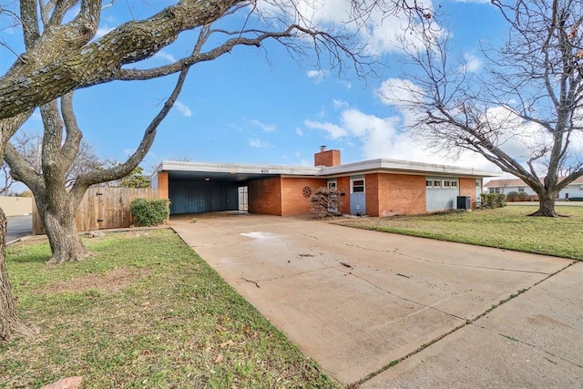 single story home featuring cooling unit, a front yard, and a carport