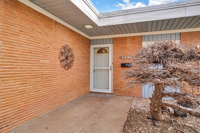 view of exterior entry with a patio