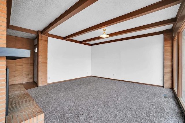 unfurnished living room with carpet, a textured ceiling, and beam ceiling