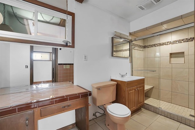 bathroom featuring vanity, toilet, a shower with shower door, and tile patterned flooring