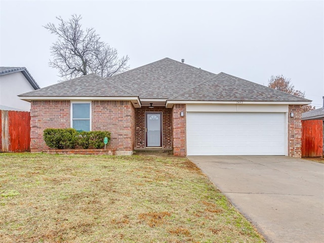 ranch-style home with a garage and a front yard